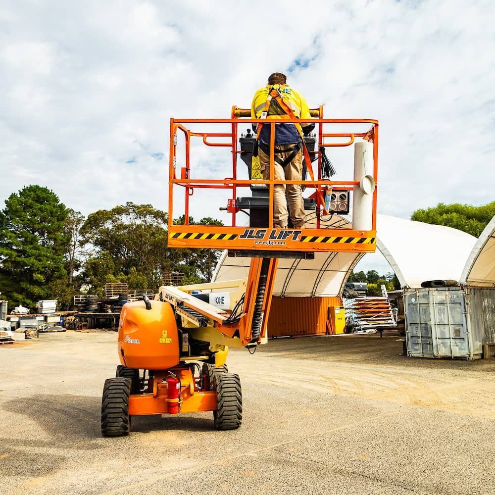 A Man is Standing on a Lift That Says Jlg Lift — One Group Industries Pty Ltd in Bathurst, NSW