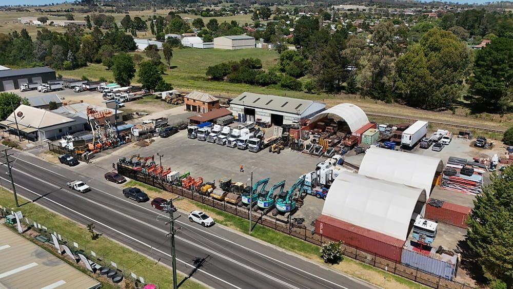 An Aerial View of a Warehouse With a Lot of Vehicles Parked — One Group Industries Pty Ltd in Bathurst, NSW