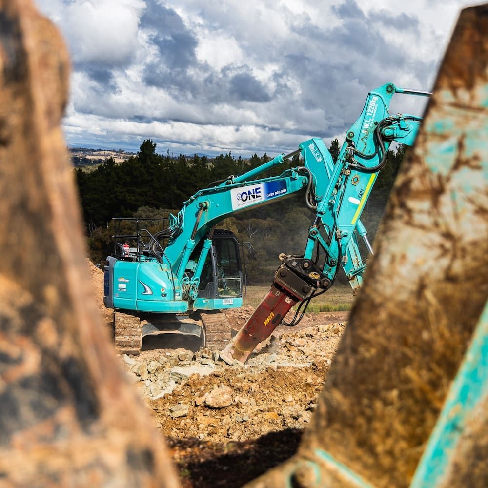 A Blue Excavator is Digging a Hole in the Ground — One Group Industries Pty Ltd in Bathurst, NSW