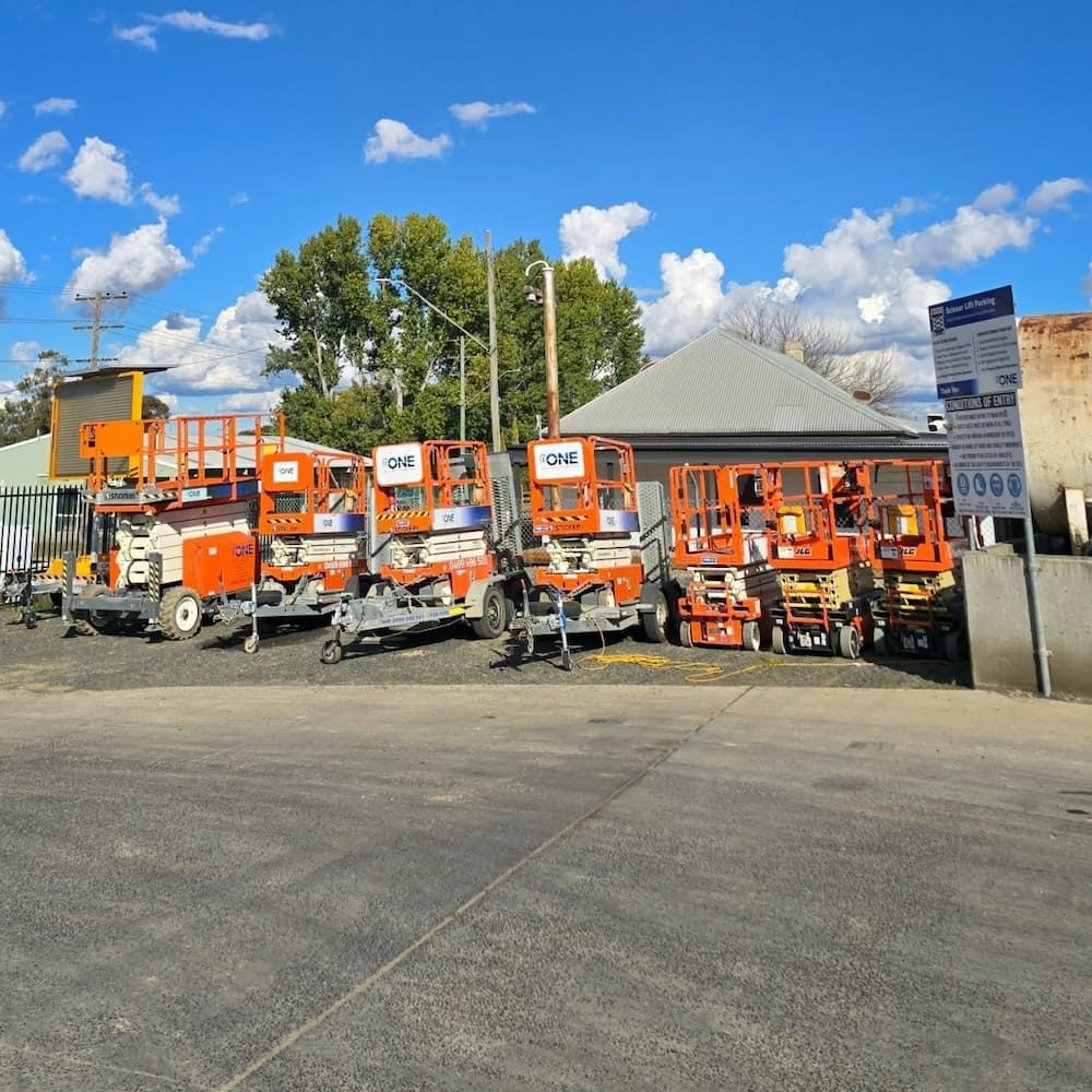 A Row of Orange Vehicles Are Parked in Front of a Building — One Group Industries Pty Ltd in Bathurst, NSW