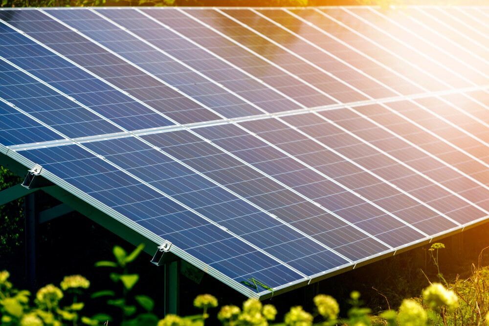 A Row of Solar Panels Sitting on Top of a Lush Green Field — One Group Industries Pty Ltd in Bathurst, NSW