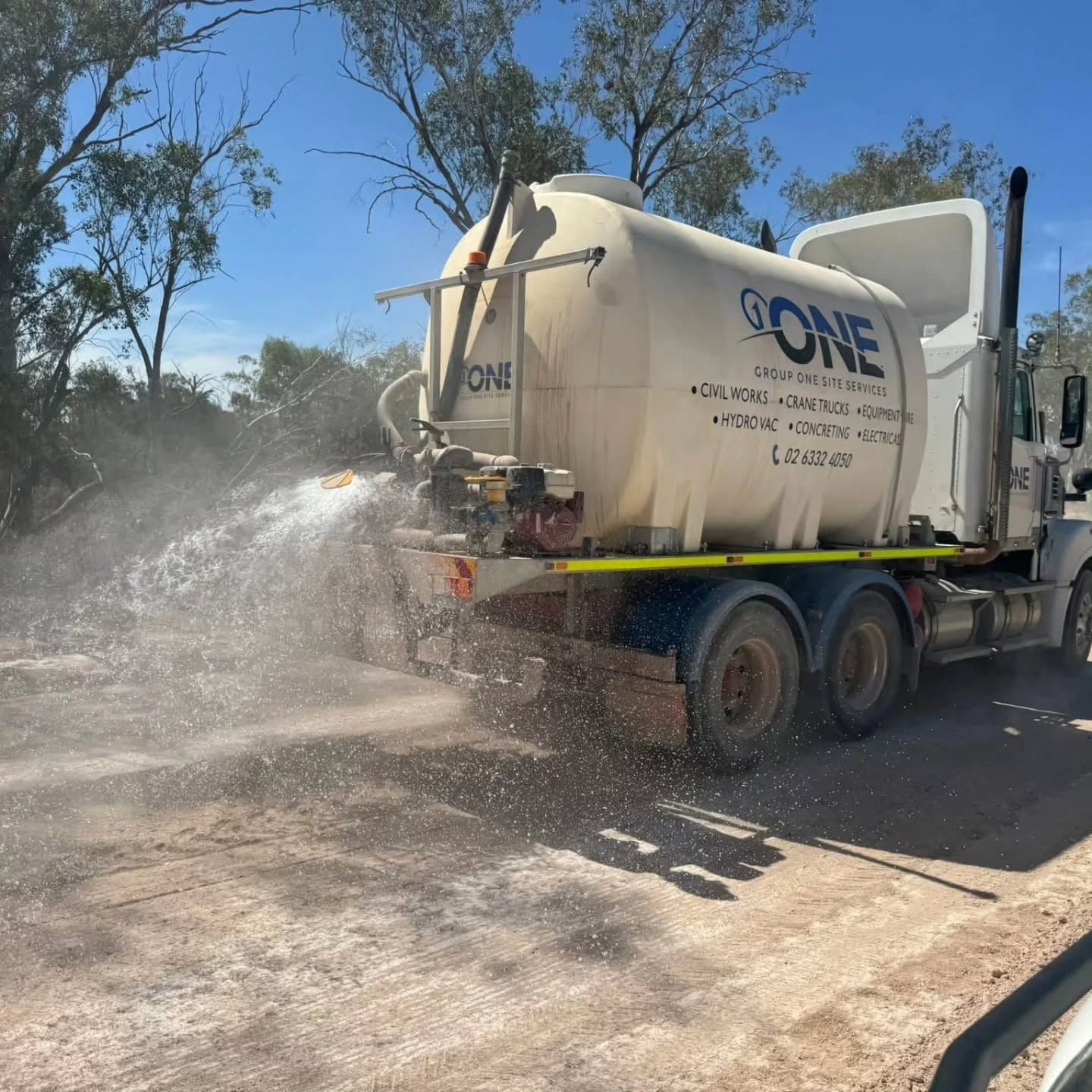 A Truck With a Crane on the Back is Parked on a Dirt Road — One Group Industries Pty Ltd in Bathurst, NSW