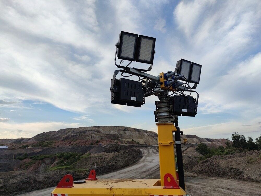 A Yellow Tower With a Lot of Lights on It is Sitting on Top of a Dirt Road — One Group Industries Pty Ltd in Bathurst, NSW