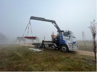 A Truck is Carrying a Trailer With a Bunch of Tractors on It — One Group Industries Pty Ltd in Bathurst, NSW