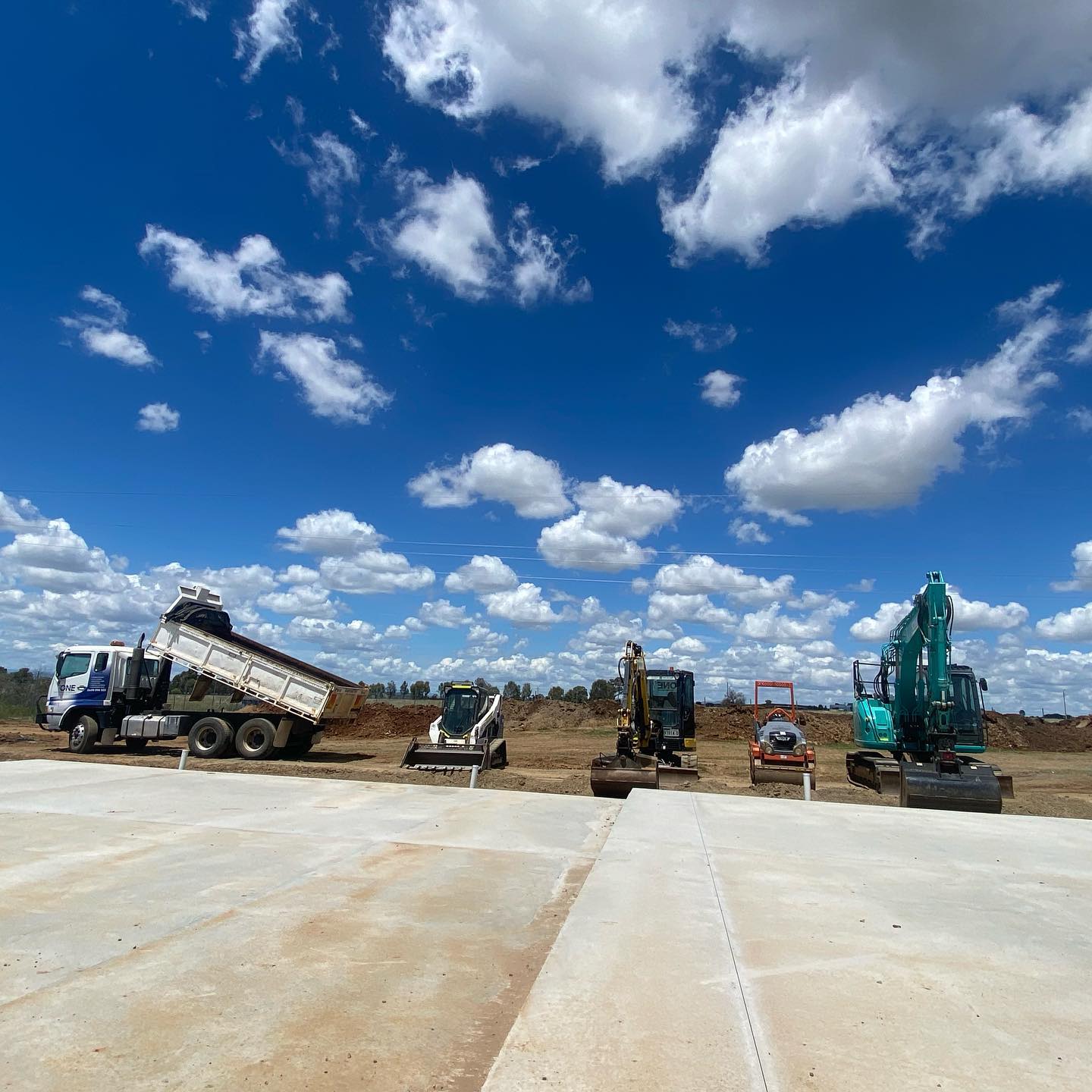 A Dump Truck is Being Loaded With Dirt on a Construction Site — One Group Industries Pty Ltd in Bathurst, NSW