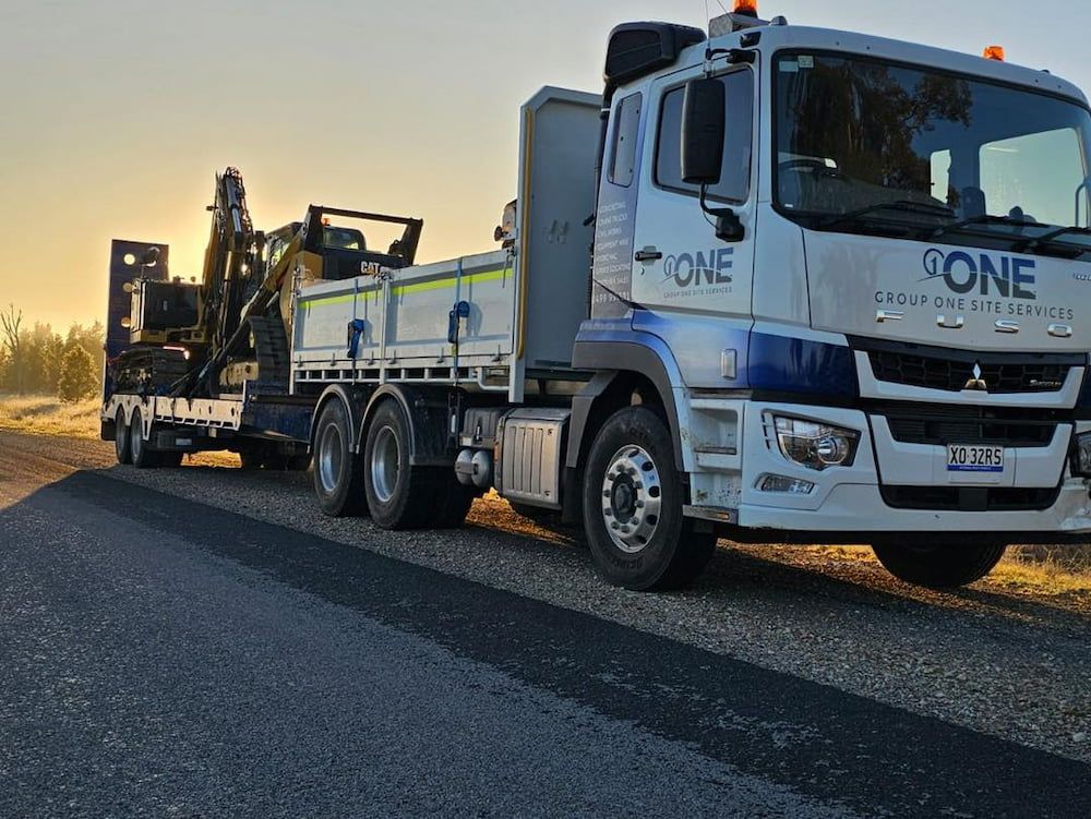 A Dump Truck is Parked on the Side of the Road Next to a Trailer — One Group Industries Pty Ltd in Bathurst, NSW