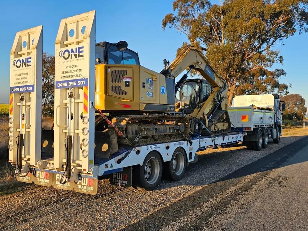 A Truck is Carrying a Large Excavator on a Trailer — One Group Industries Pty Ltd in Bathurst, NSW