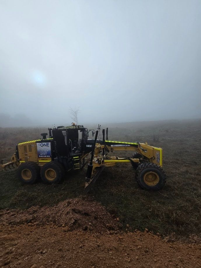 A Road Grader Working on A Dirt Surface in A Field — One Group Industries Pty Ltd in Bathurst, NSW