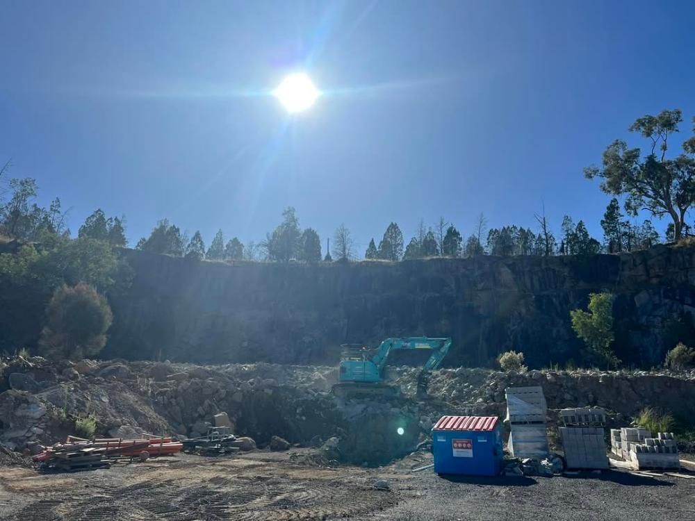 A Large Excavator is Sitting in the Middle of a Construction Site — One Group Industries Pty Ltd in Bathurst, NSW