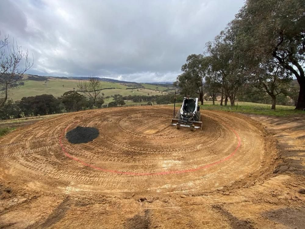 A Bulldozer is Driving on a Dirt Road in a Field — One Group Industries Pty Ltd in Bathurst, NSW