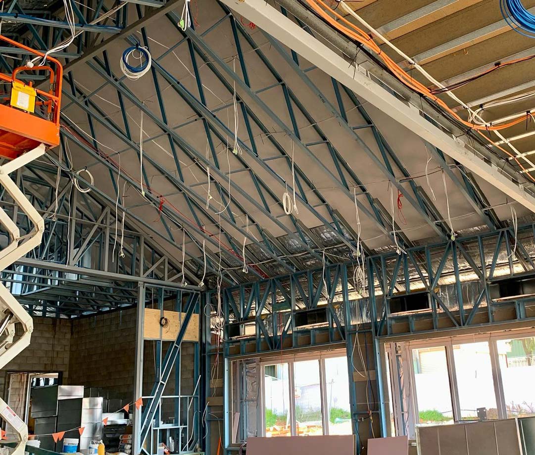 Construction site interior with metal framing and insulation on a sloped ceiling — One Group Industries Pty Ltd in Bathurst, NSW