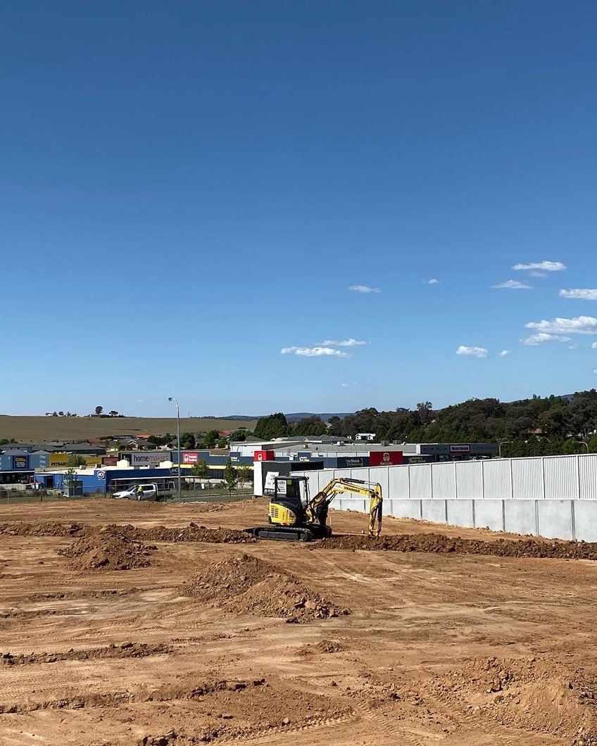 Excavator on a construction site with brown earth — One Group Industries Pty Ltd in Bathurst, NSW