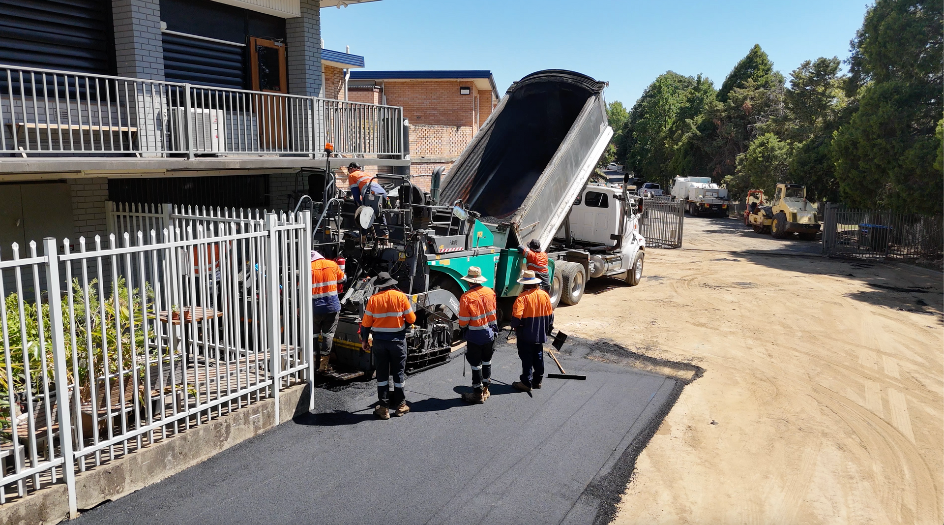 A Worker Rakes Fresh Asphalt onto A Road at A Construction Site — One Group Industries Pty Ltd in Bathurst, NSW