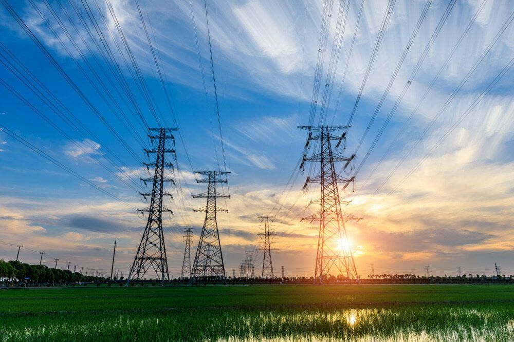 A Row of Power Lines in a Field at Sunset — One Group Industries Pty Ltd in Bathurst, NSW