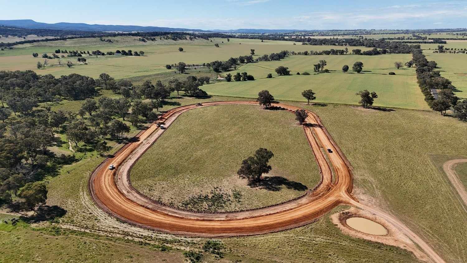 Aerial View of A Dirt Track in A Green Field — One Group Industries Pty Ltd in Bathurst, NSW