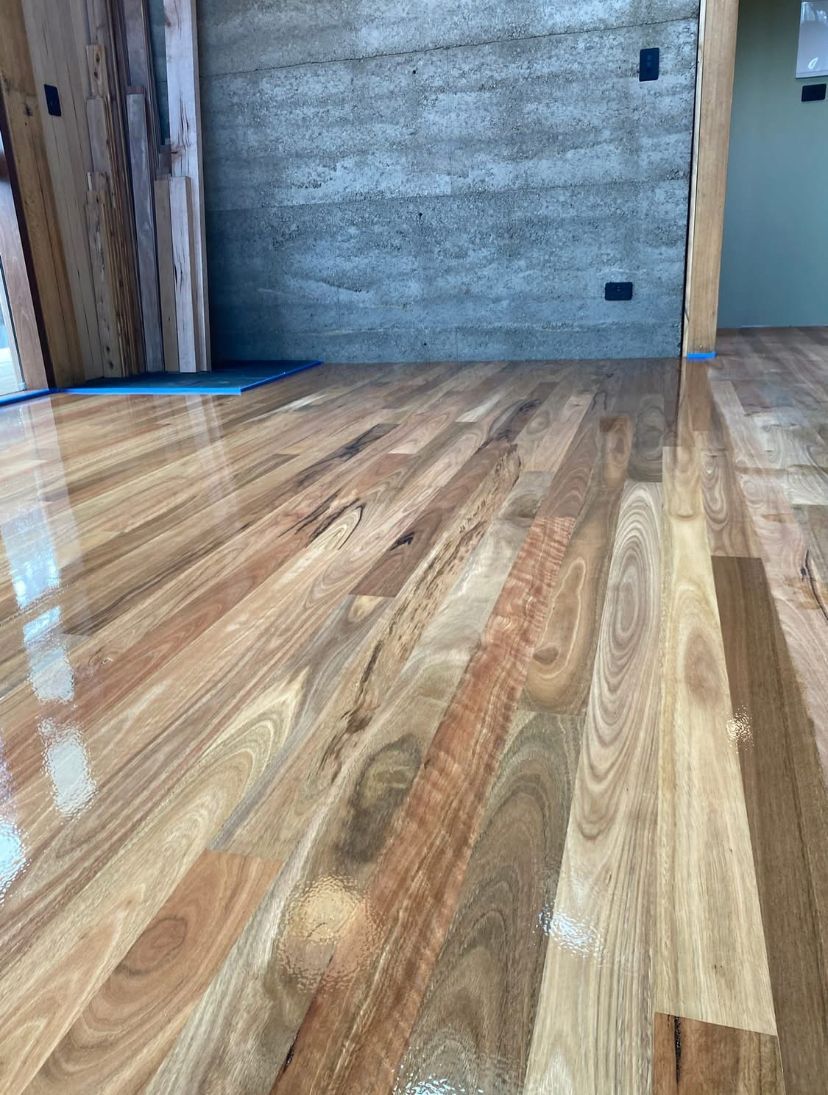 Polished wood floor in an unfinished room with gray walls and doorway trim — Finer Floors In Cambridge, TAS