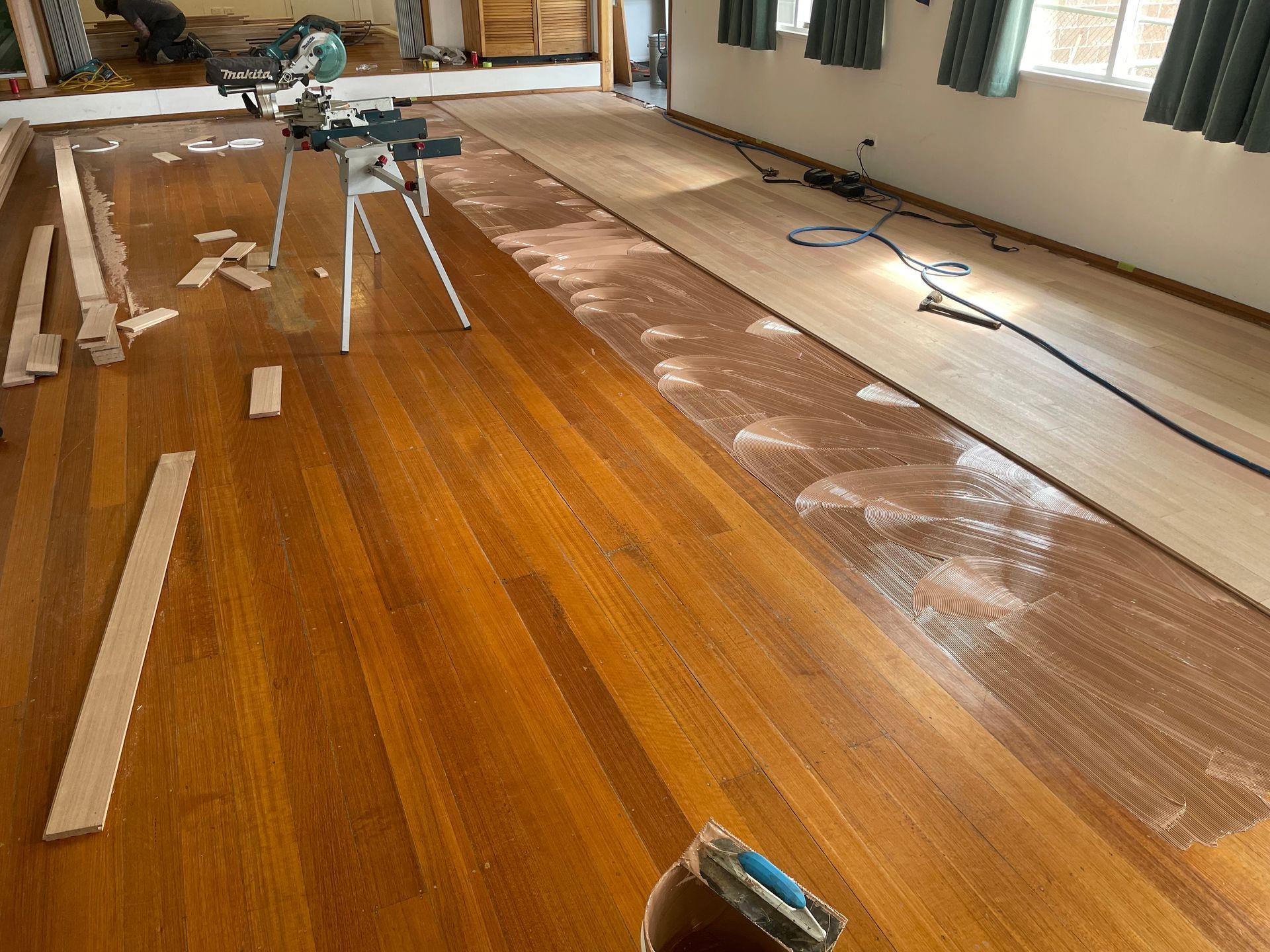 Wooden floor being refinished, with sanding equipment and dust in a room during renovation. — Finer Floors In Cambridge, TAS