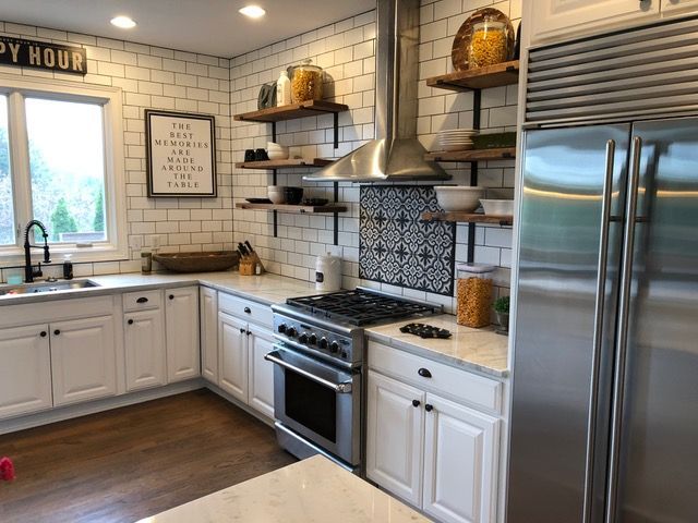 A kitchen with white cabinets and stainless steel appliances.