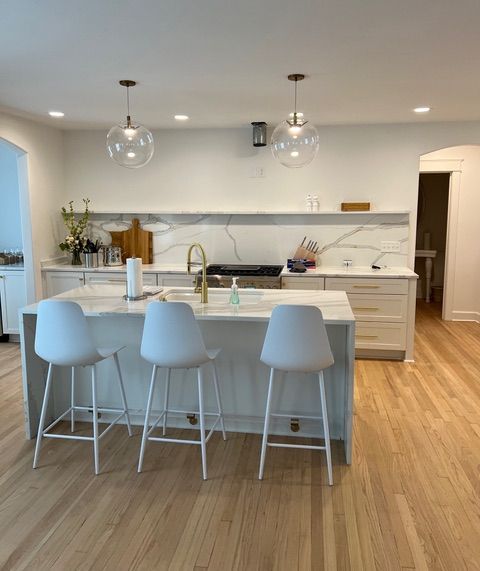 A kitchen with a large island and stools