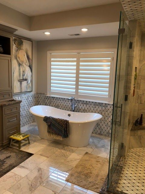 A bathroom with a tub , shower and window. A bathroom with a tub , shower and window.