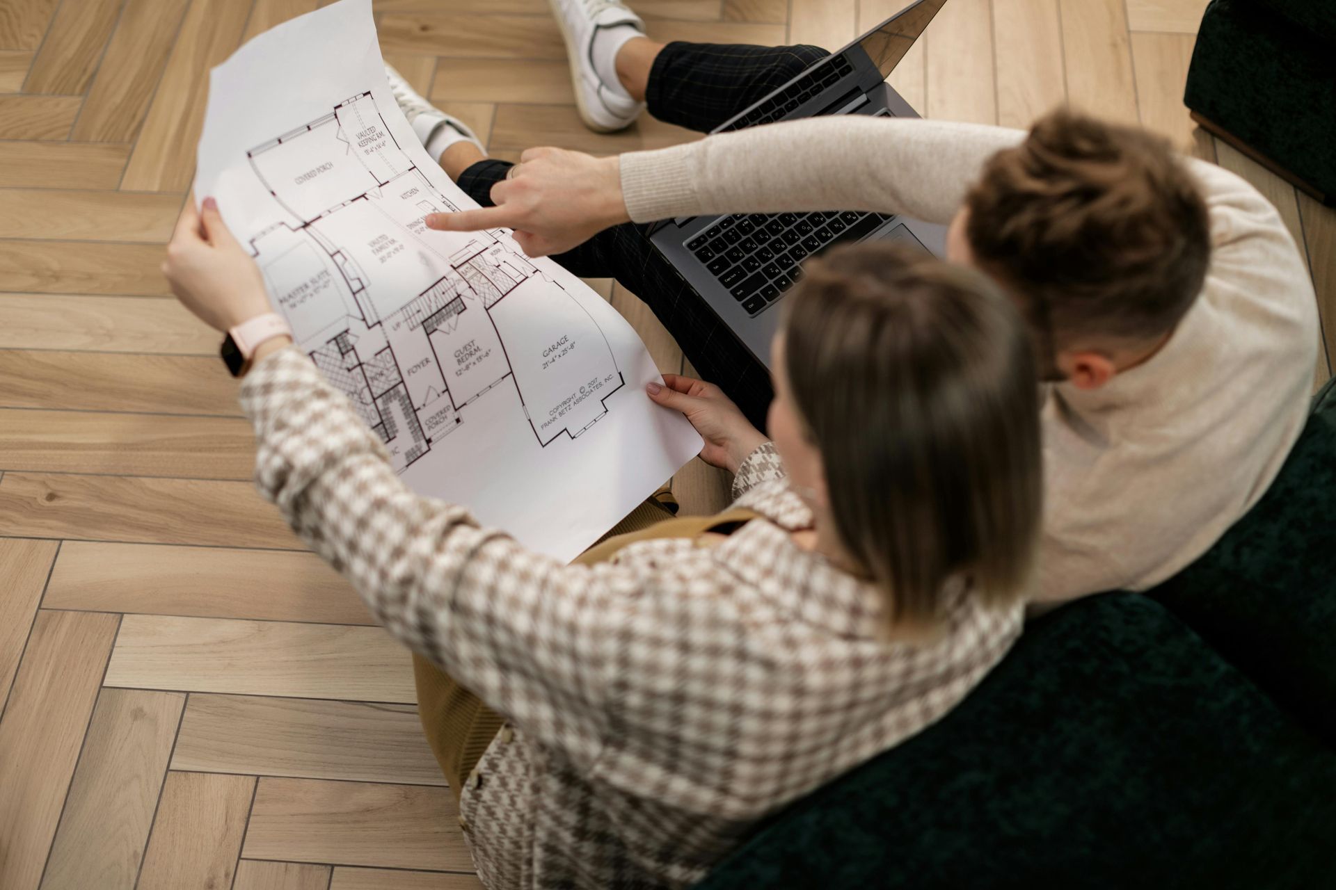 Homeowners collaborating with a designer during a basement remodeling consultation. Homeowners collaborating with a designer during a basement remodeling consultation.