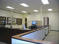 There is a computer on the desk in the middle of the room.