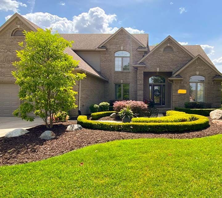 A home with landscaping and bushes in the front yard.