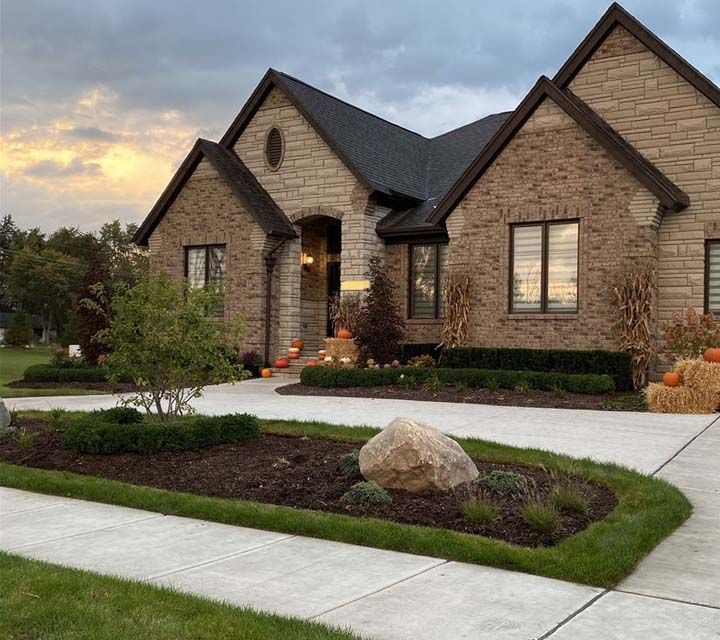A home with a stone driveway and landscaping.