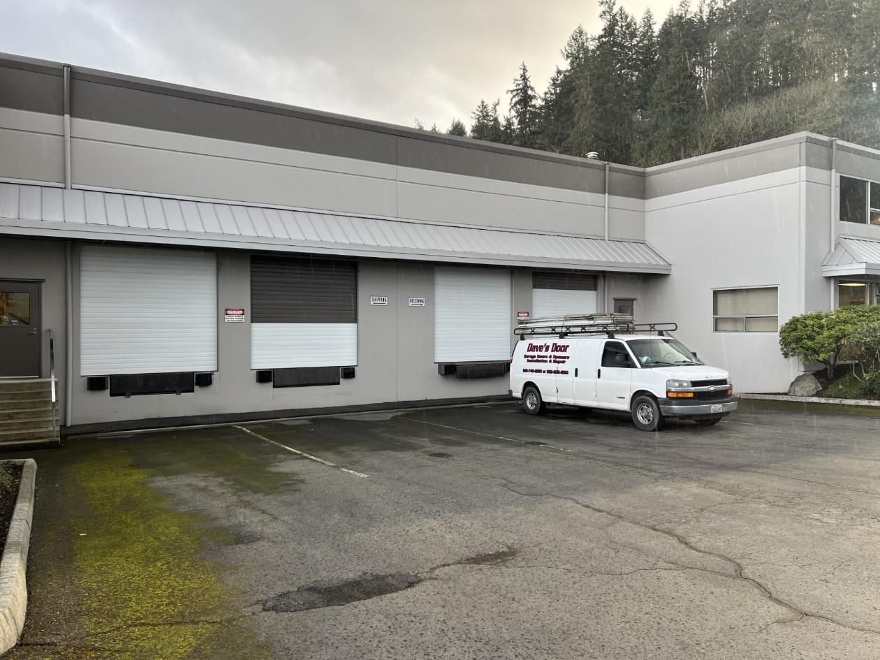 Exterior of a light gray industrial building with loading docks.