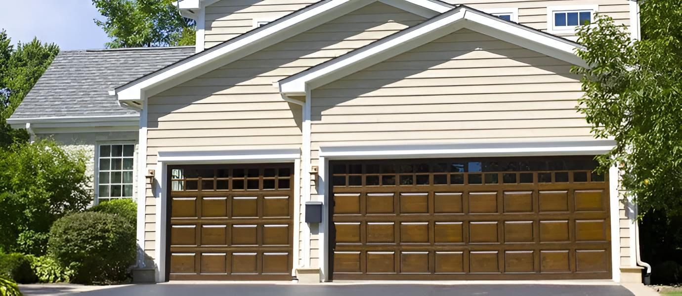Beige house with two brown garage doors.