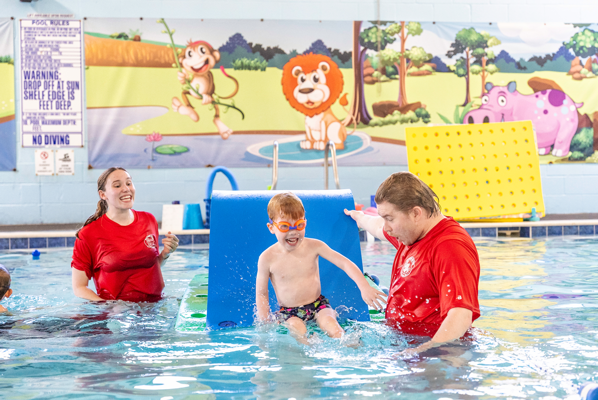 A group of people are playing in a swimming pool.