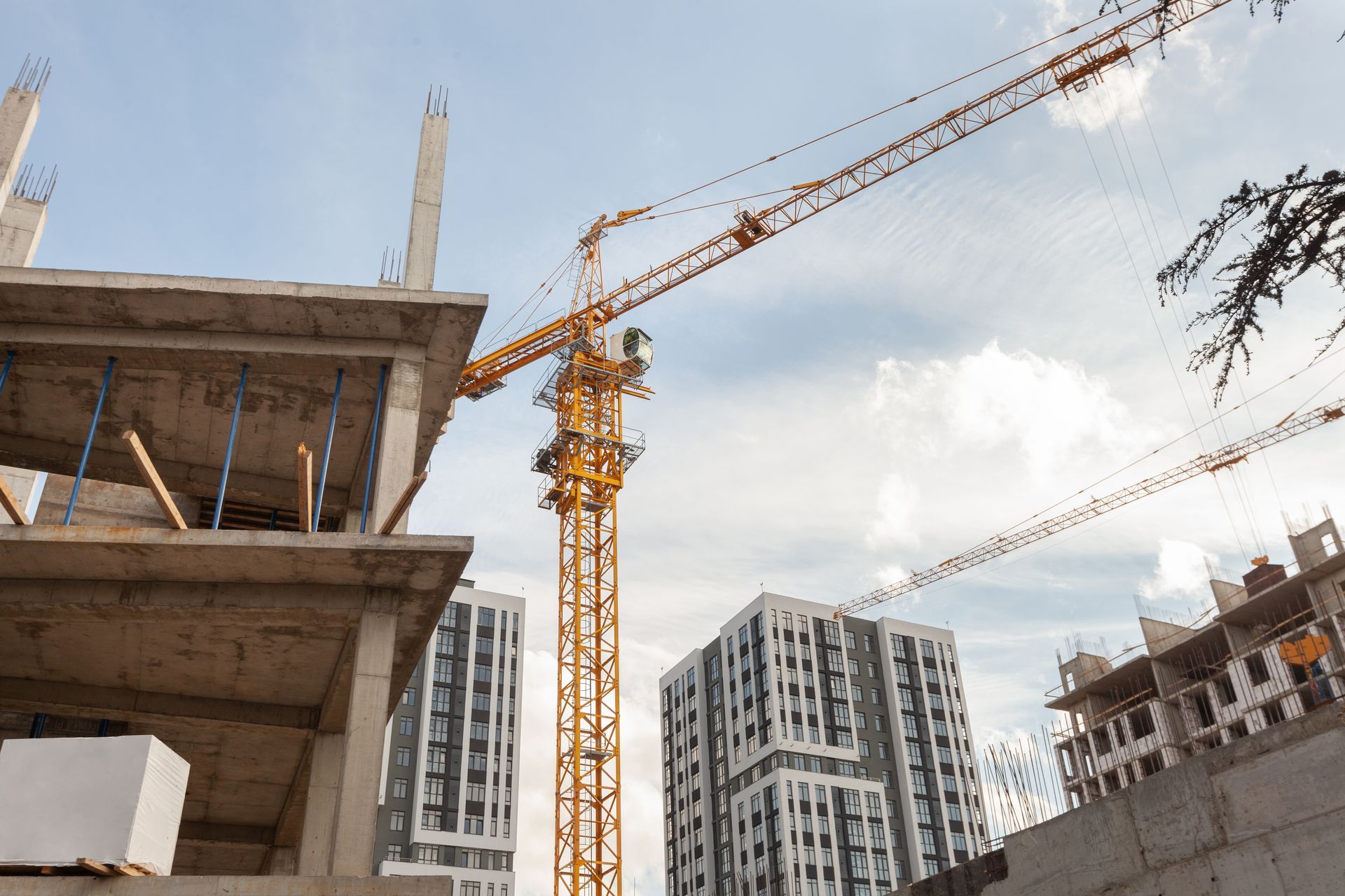 Professional construction services with crane lifting materials at a multi-story building site.