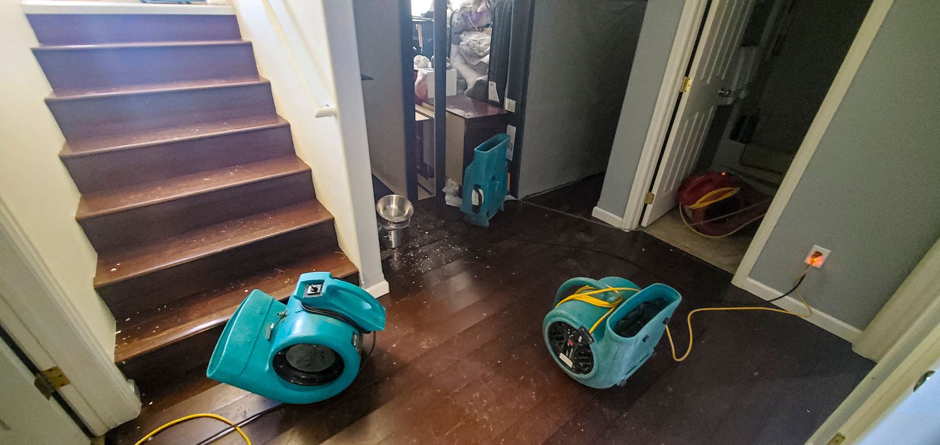 Air movers in place to dry out a home after a water damage flood caused by a plumbing pipe break.
