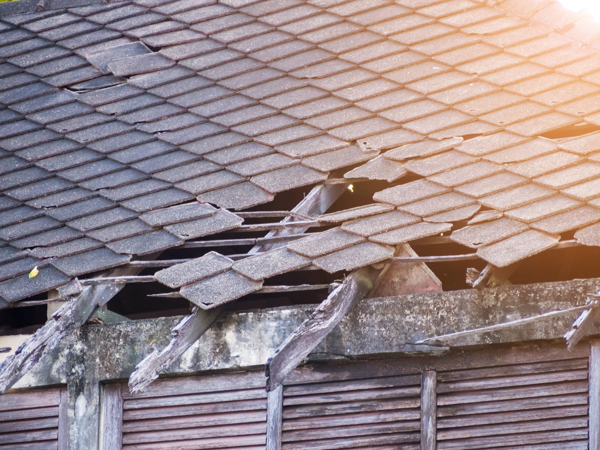 Broken tile roof showing need for expert storm damage restoration after heavy winds.