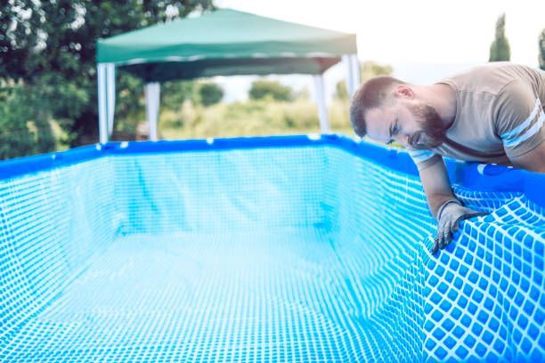 A man is working on the inside of a swimming pool.