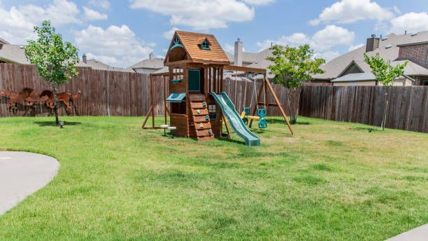 There is a playground in the backyard of a house.