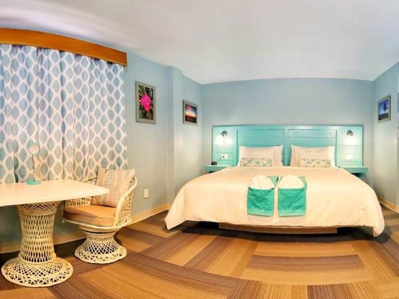 A hotel room with a king size bed and a table