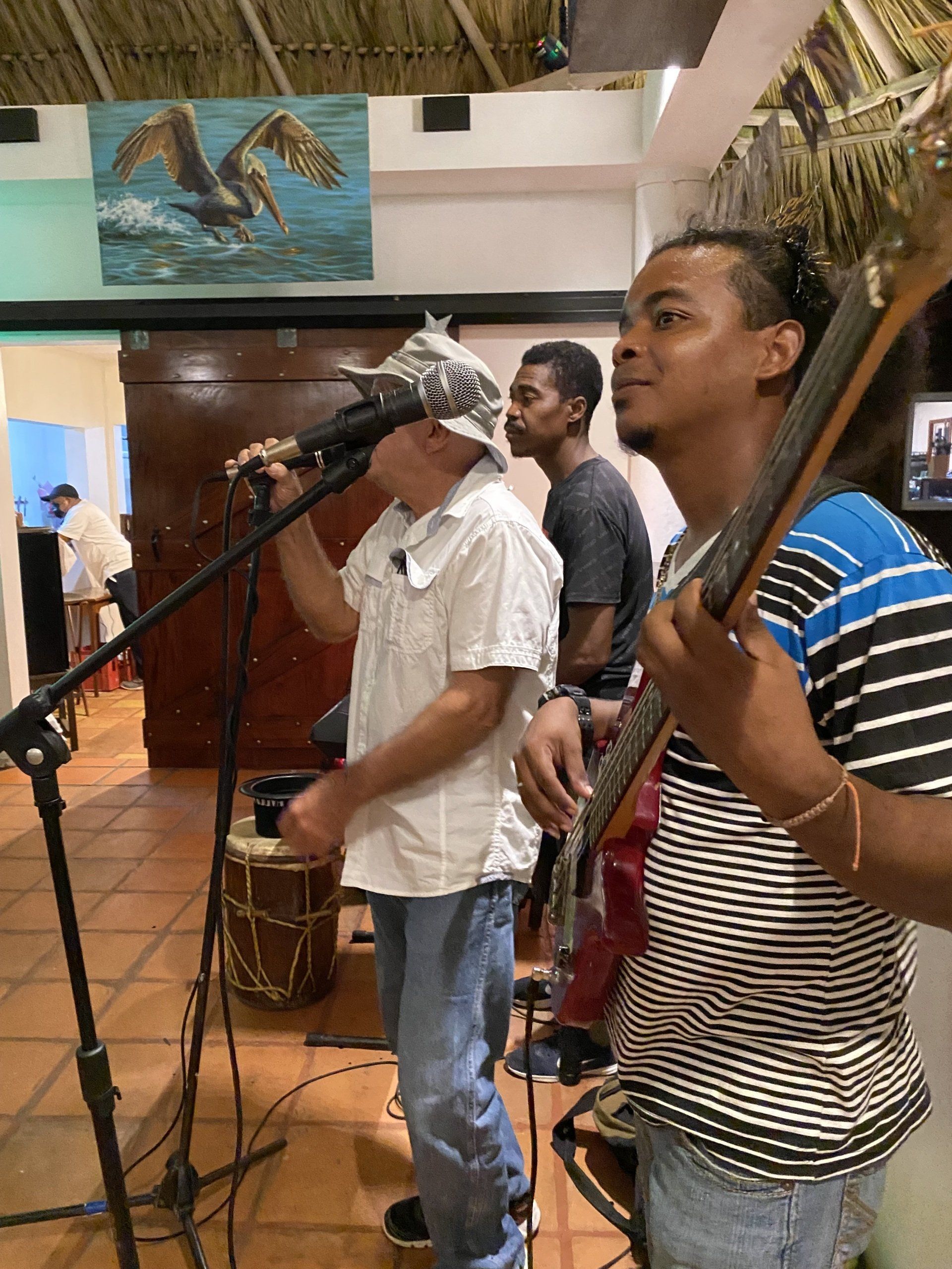 A group of men are playing instruments and singing into microphones.