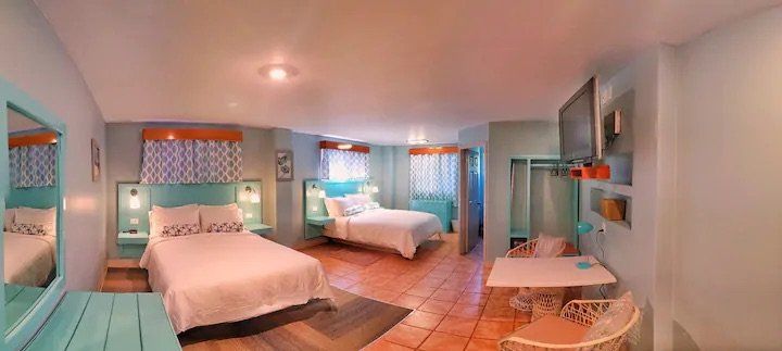 A hotel room with two beds , a table and chairs.