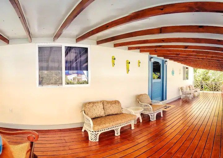 A wooden deck with a couch and chairs on it