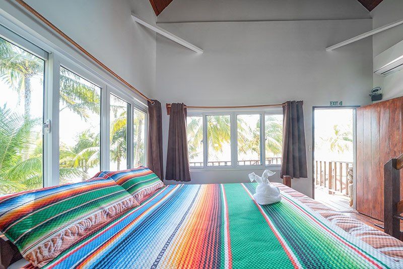 A bedroom with a king size bed and lots of windows.