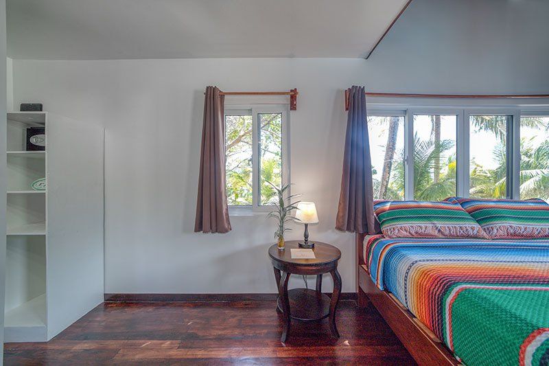 A bedroom with a bed , nightstand , and window.