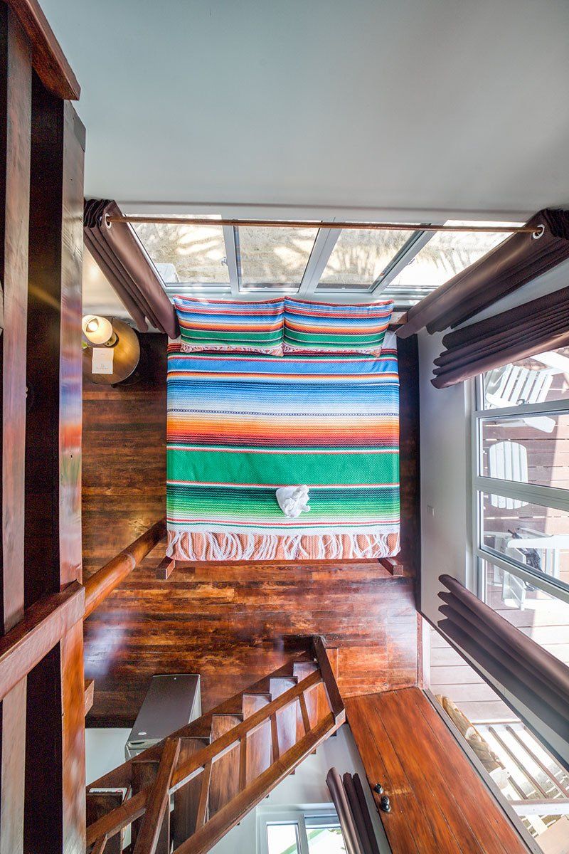 An aerial view of a bedroom with a bed and stairs.