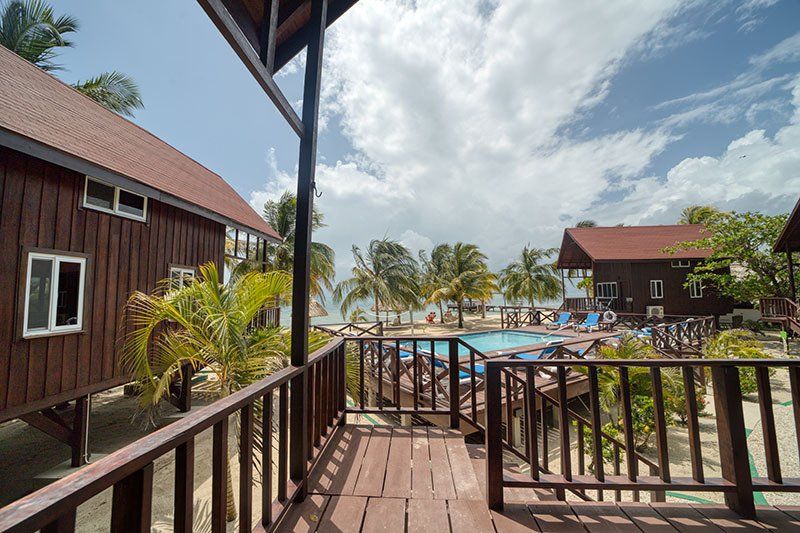 A balcony overlooking a swimming pool and a beach.
