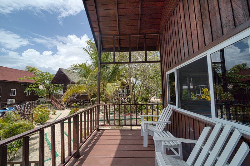 A balcony with chairs and a table on a wooden deck.