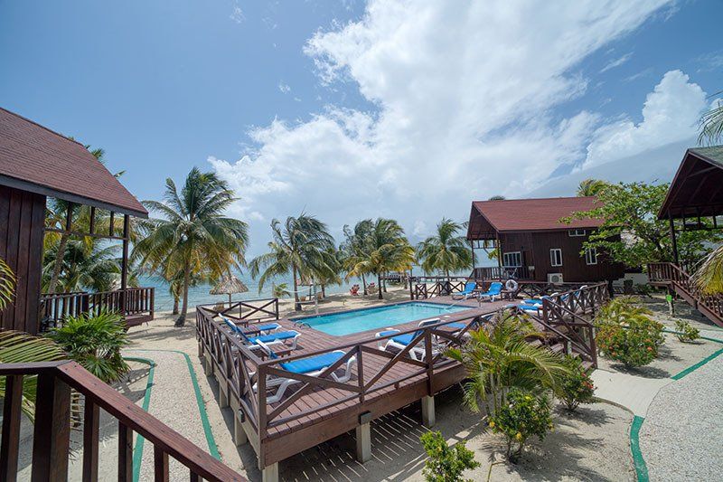 There is a large swimming pool in the middle of a tropical resort.