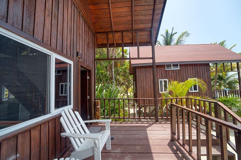 A wooden deck with a chair and a window