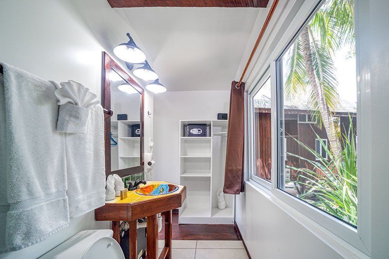 A bathroom with a sink , mirror , and window.