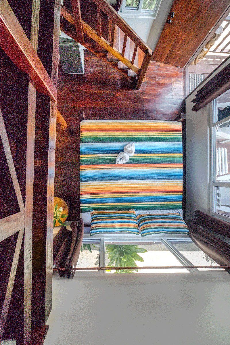An aerial view of a living room with a colorful rug and stairs.