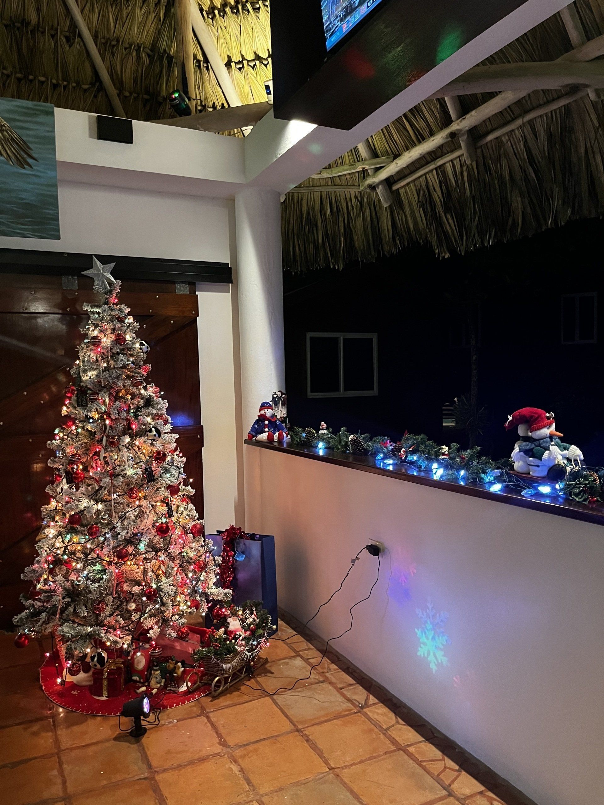 A christmas tree is sitting in a room next to a wall.